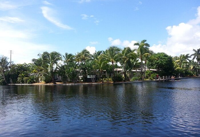 The Cabanas Guesthouse & Spa, a gay-friendly resort. Waterfront view with palm trees. A relaxing gay men's travel destination.