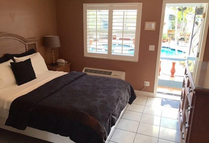 Coral Reef Guesthouse room with bed, pool view. Gay-friendly hotel room. Travel advice for gay men. Comfortable lodging. Relaxing vacation.