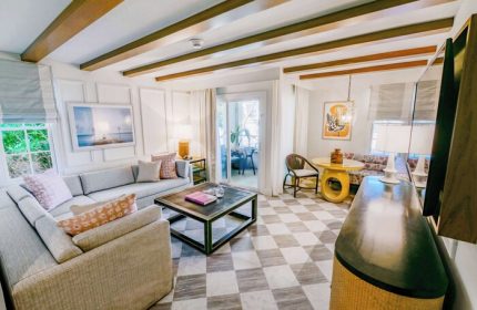 Casa Marina Key West, Curio Collection by Hilton suite. Living area with sofa, table, and balcony. Gay-friendly hotel interior.