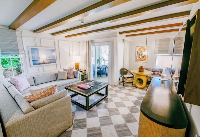 Casa Marina Key West, Curio Collection by Hilton suite. Living area with sofa, table, and balcony. Gay-friendly hotel interior.