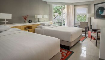 Hyatt Centric Key West Resort And Spa guest room with two beds, balcony, and modern decor. Gay-friendly hotel room for gay men travel.