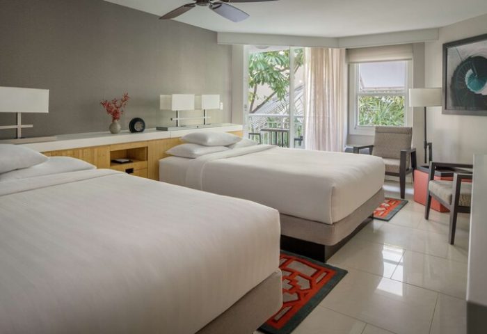 Hyatt Centric Key West Resort And Spa guest room with two beds, balcony, and modern decor. Gay-friendly hotel room for gay men travel.