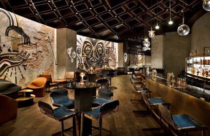 Hotel Indigo Dubai Downtown bar interior. Gay-friendly hotel with artful design, modern seating, and a stylish bar area. Perfect for gay travelers.