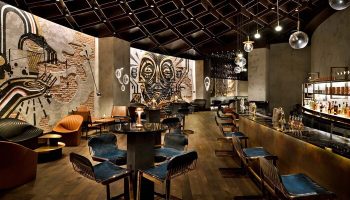 Hotel Indigo Dubai Downtown bar interior. Gay-friendly hotel with artful design, modern seating, and a stylish bar area. Perfect for gay travelers.