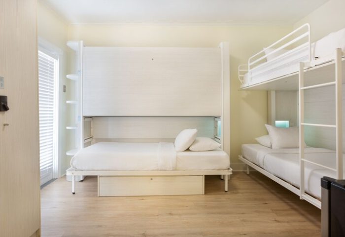 NYAH Key West Gay-Friendly Hotel room. White Murphy bed and bunk beds with white linens. Adults-only lodging for gay men's travel.