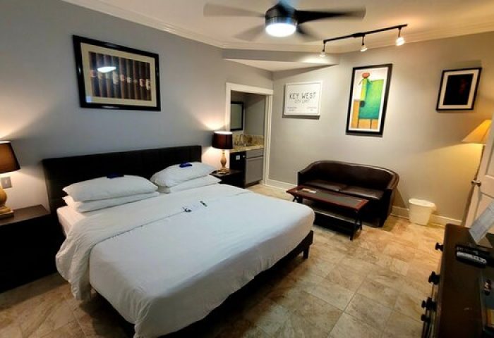 Equator Resort gay-friendly hotel room. King bed, sofa, & Key West art. Perfect for gay travel. Relax at this welcoming hotel.