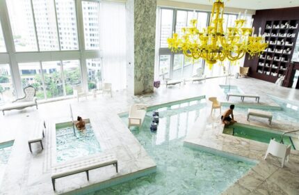 W Miami gay-friendly hotel spa with pools, yellow chandelier, and city views. Marble floors and modern design. Luxury travel for gay men.