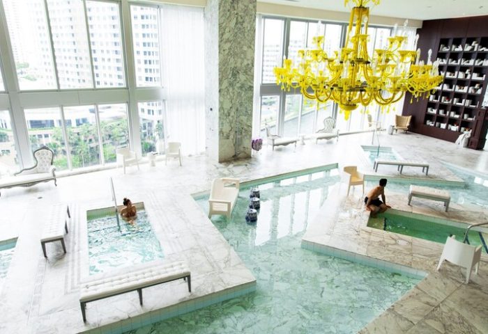 W Miami gay-friendly hotel spa with pools, yellow chandelier, and city views. Marble floors and modern design. Luxury travel for gay men.
