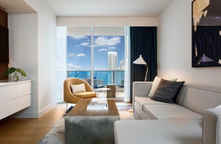 Kimpton EPIC Hotel gay-friendly room. Modern living room with a view of Miami's skyline and ocean. Stylish, comfortable, and inviting for gay travelers.