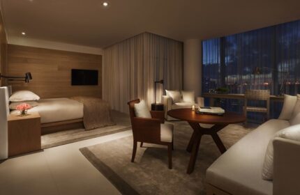 Miami Beach EDITION gay-friendly hotel room. Modern design, bed, seating area, and city view. Luxury travel for gay men. Interior design.
