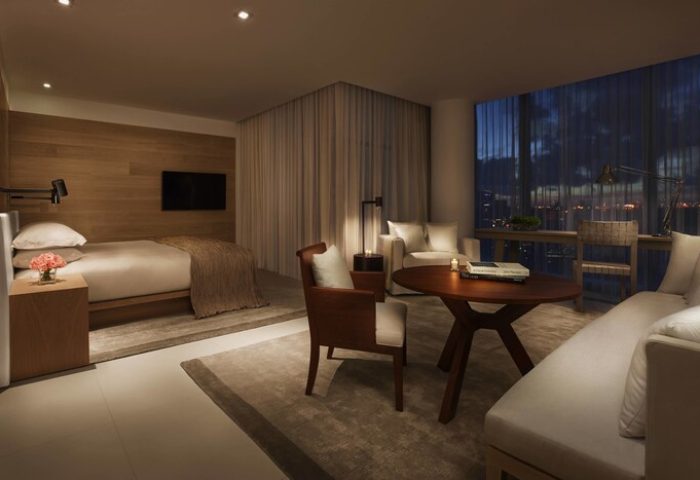 Miami Beach EDITION gay-friendly hotel room. Modern design, bed, seating area, and city view. Luxury travel for gay men. Interior design.