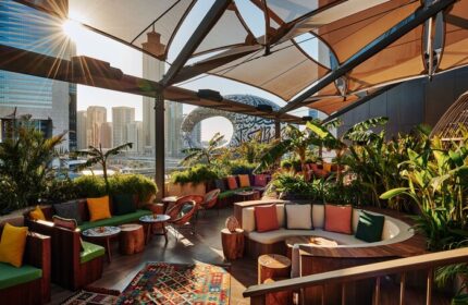 25hours Hotel One Central rooftop bar with city view. Gay-friendly hotel with outdoor seating, plants, and colorful decor. Dubai travel advice.