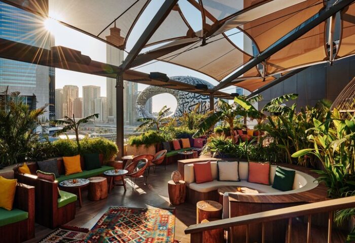 25hours Hotel One Central rooftop bar with city view. Gay-friendly hotel with outdoor seating, plants, and colorful decor. Dubai travel advice.