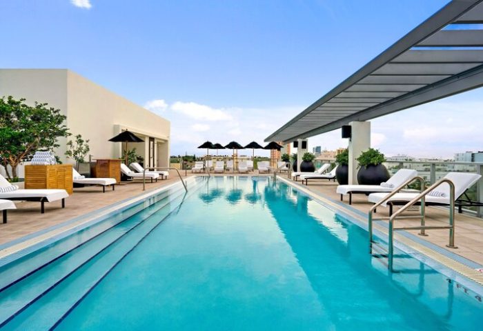 Kimpton Angler's Hotel gay-friendly rooftop pool. Lounge chairs and umbrellas line the pool. A great spot for gay men to relax and enjoy.