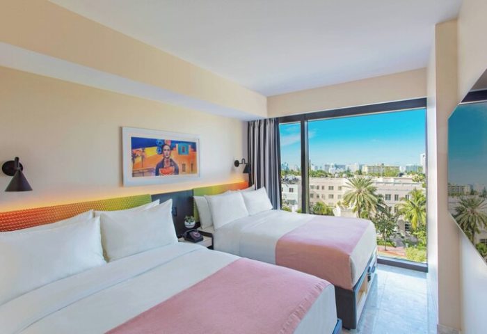 Moxy Miami South Beach gay-friendly hotel room. Two beds, city view, and colorful decor. Great for gay men travel.