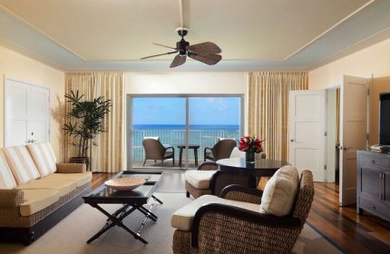 Kahala Hotel and Resort gay-friendly suite. Ocean view from the balcony, wicker furniture, ceiling fan. Luxury travel for gay men.