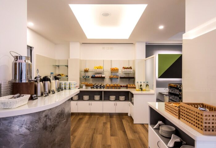 Breakfast bar at the Gay-Friendly 43 Station Hotel. Buffet with fruit, pastries, coffee, and juice. Modern design, clean lines, and wood floors.
