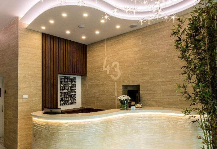 43 Station Hotel's lobby. Gay-friendly hotel with a modern reception area, starburst lighting, and sleek design elements. Ideal for gay travel.