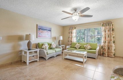 Coconut Bay Resort gay-friendly hotel room. Living area with sofas, ceiling fan, and tropical decor. Ideal for gay men's travel.