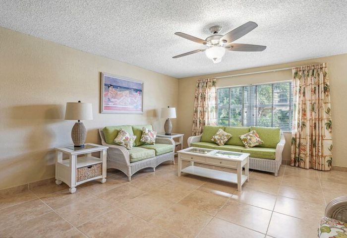 Coconut Bay Resort gay-friendly hotel room. Living area with sofas, ceiling fan, and tropical decor. Ideal for gay men's travel.