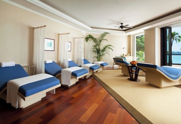 Moana Surfrider, Waikiki Beach spa. Gay-friendly hotel with blue lounge chairs, tropical plants, and ocean view. Relax at this Westin Resort.