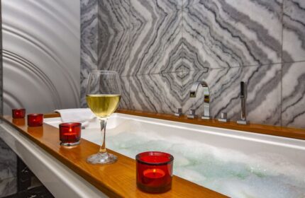 Elysium Taksim Hotel gay-friendly bath. Wine glass and candles by a tub with marble tile. Relax at this gay Istanbul hotel.