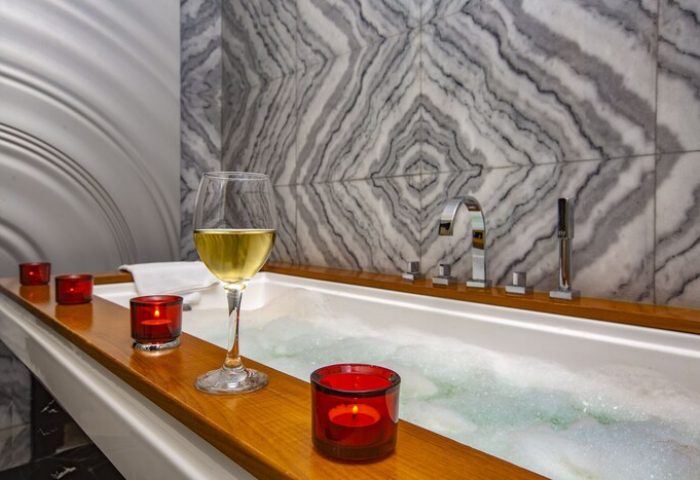 Elysium Taksim Hotel gay-friendly bath. Wine glass and candles by a tub with marble tile. Relax at this gay Istanbul hotel.