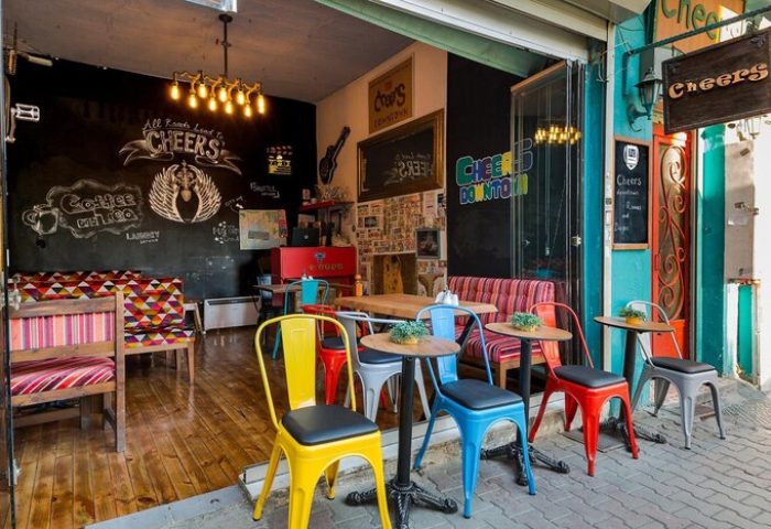 Cheers Midtown Hostel's gay-friendly hotel cafe. Colorful chairs and tables outside. Chalkboard art inside. A welcoming space for gay travelers.