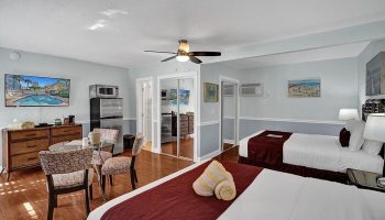 Room at The Grand Resort and Spa, an all-male spa resort. Gay-friendly hotel room with two beds, a kitchenette, and a dining area.