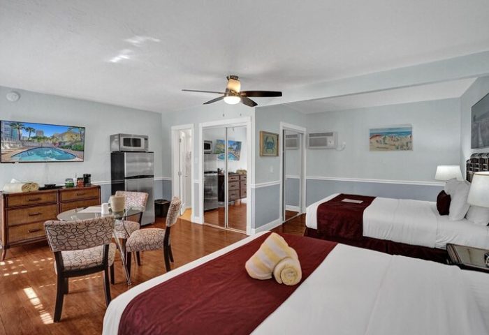 Room at The Grand Resort and Spa, an all-male spa resort. Gay-friendly hotel room with two beds, a kitchenette, and a dining area.