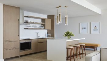 Four Seasons Hotel and Residences Fort Lauderdale gay-friendly hotel kitchen. Modern design with island, stools, and open shelving.