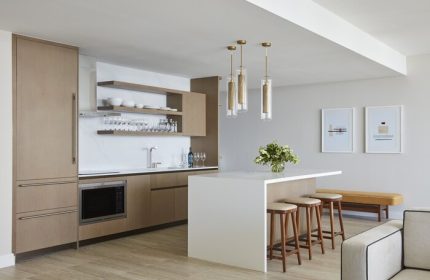 Four Seasons Hotel and Residences Fort Lauderdale gay-friendly hotel kitchen. Modern design with island, stools, and open shelving.