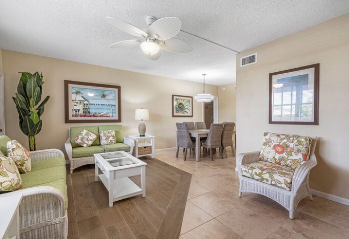 Coconut Bay Resort gay-friendly hotel room. Wicker furniture, floral cushions, dining table. Tropical decor for gay men travel.