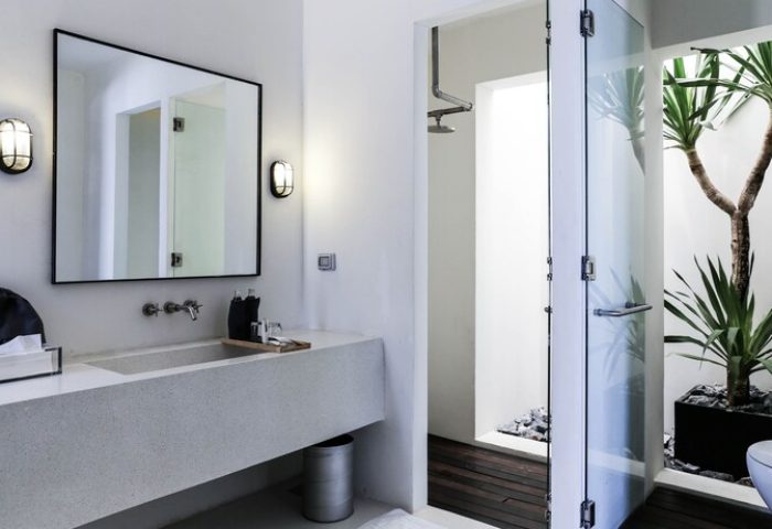 Cross River Kwai gay-friendly hotel bathroom. Modern design with stone sink, mirror, shower, and indoor plant. X2 River Kwai luxury travel.