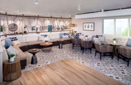 Lounge area at The Reach Key West, Curio Collection by Hilton. Gay-friendly hotel with stylish seating, tables, and patterned floor. Relaxing space.