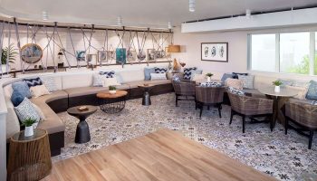 Lounge area at The Reach Key West, Curio Collection by Hilton. Gay-friendly hotel with stylish seating, tables, and patterned floor. Relaxing space.