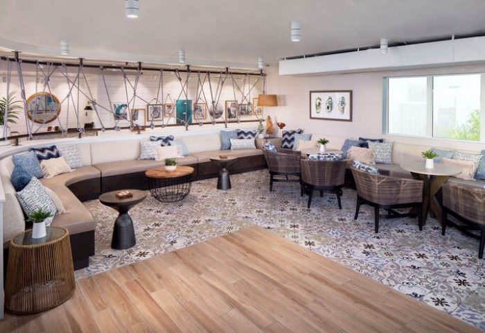 Lounge area at The Reach Key West, Curio Collection by Hilton. Gay-friendly hotel with stylish seating, tables, and patterned floor. Relaxing space.
