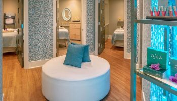 Hyatt Centric Key West Resort And Spa's gay-friendly spa. Round white ottoman with blue pillows, treatment rooms, and OSEA products on display.
