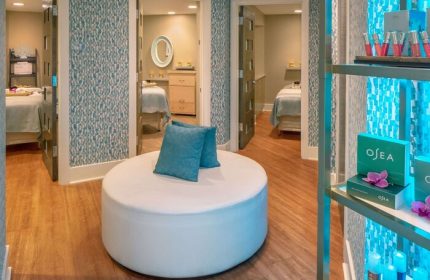 Hyatt Centric Key West Resort And Spa's gay-friendly spa. Round white ottoman with blue pillows, treatment rooms, and OSEA products on display.