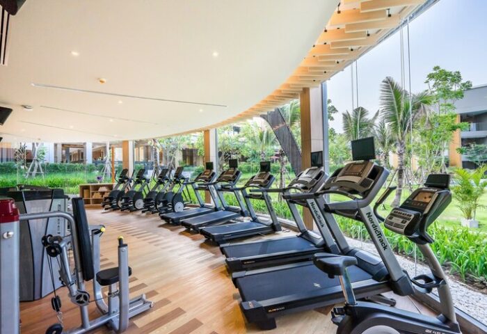 Avani+ Hua Hin Resort's gym. A gay-friendly hotel with treadmills and exercise bikes. Fitness center with modern equipment and natural light.