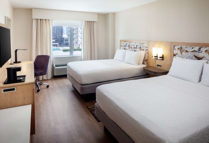 Hampton Inn & Suites Miami/Brickell-Downtown gay-friendly hotel room. Two beds with white linens, desk, TV, and city view. Modern, comfortable stay.