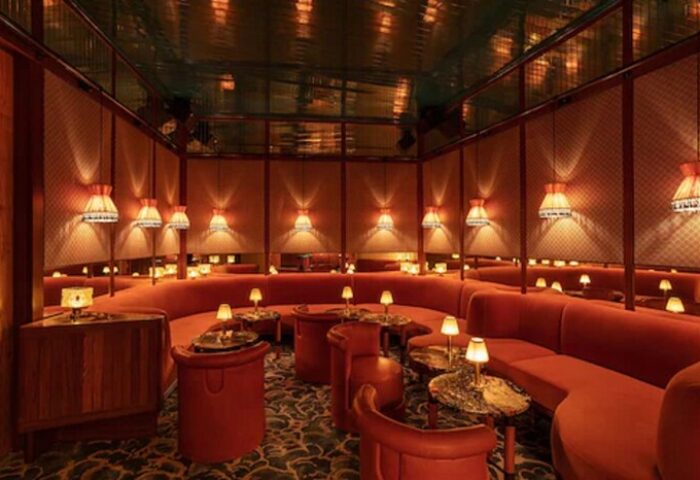 Interior of The Standard Miami, a gay-friendly hotel. Red seating wraps around tables with lamps. A stylish, welcoming space.