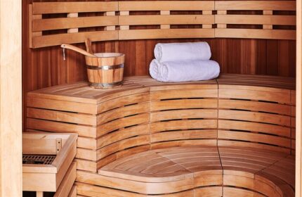 Sauna at 25hours Hotel One Central, a gay-friendly hotel. Wooden benches, bucket, and towels. Perfect for relaxation and wellness.