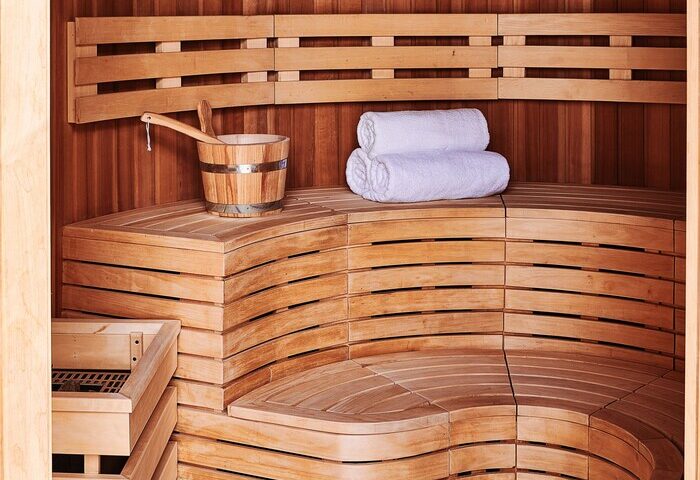 Sauna at 25hours Hotel One Central, a gay-friendly hotel. Wooden benches, bucket, and towels. Perfect for relaxation and wellness.