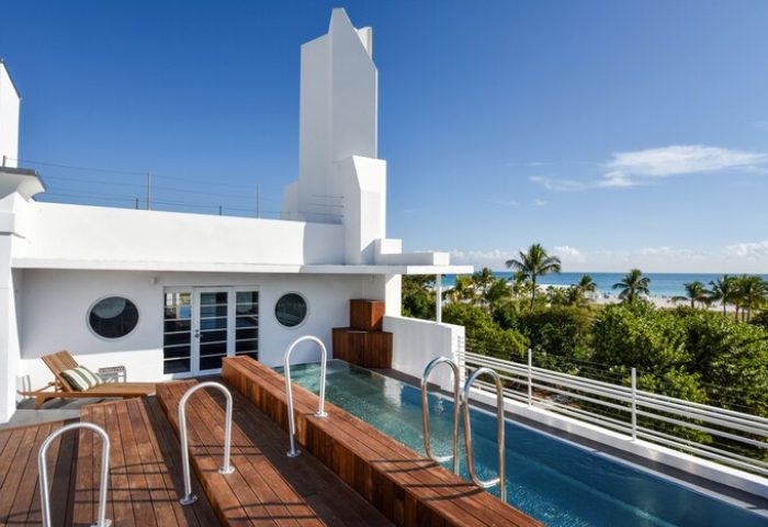 Hotel Breakwater South Beach rooftop pool. Gay-friendly hotel with ocean views, wooden deck, and white art deco architecture. Miami Beach.