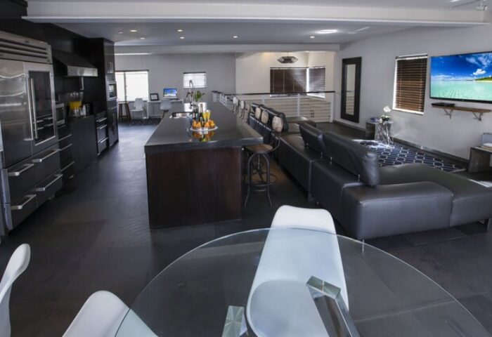 Posh South Beach gay-friendly hotel interior. Modern design with kitchen, island, living area, and TV. Upscale accommodation for gay travelers.