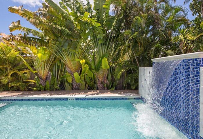 Wicker Guesthouse's pool and waterfall. Gay-friendly hotel with tropical plants. A relaxing vacation spot for gay men. Travel advice.