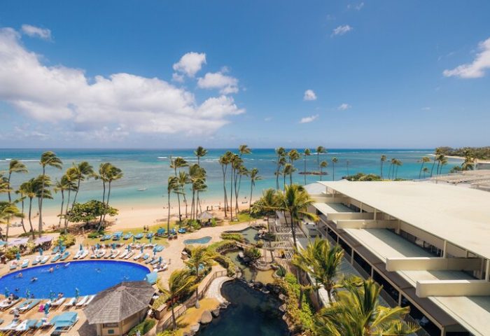 Kahala Hotel and Resort aerial view. Gay-friendly hotel with pool, beach, and palm trees. Ideal for gay men's travel in Honolulu.