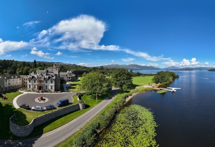 Cameron House on Loch Lomond: Gay-friendly hotel aerial view. Lochside resort with seaplane on the water. Scenic Scottish Highlands travel.