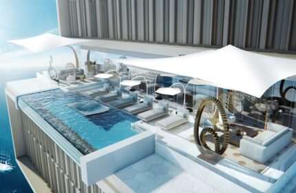 Atlantis The Royal gay-friendly hotel: rooftop pool, lounge chairs, and ocean view. Luxury travel for gay men. Modern design, relaxing vacation.